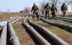 A group of soldiers walking on a bridge Description automatically generated with low confidence