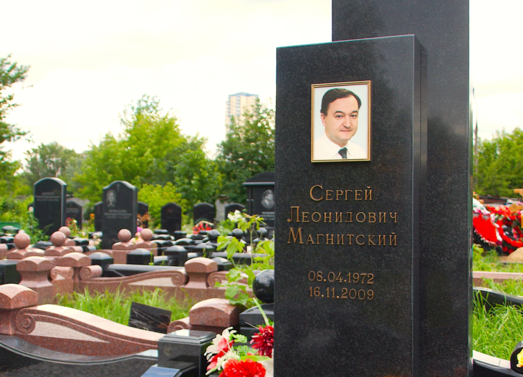A tombstone with a picture of a person on itDescription automatically generated with low confidence
