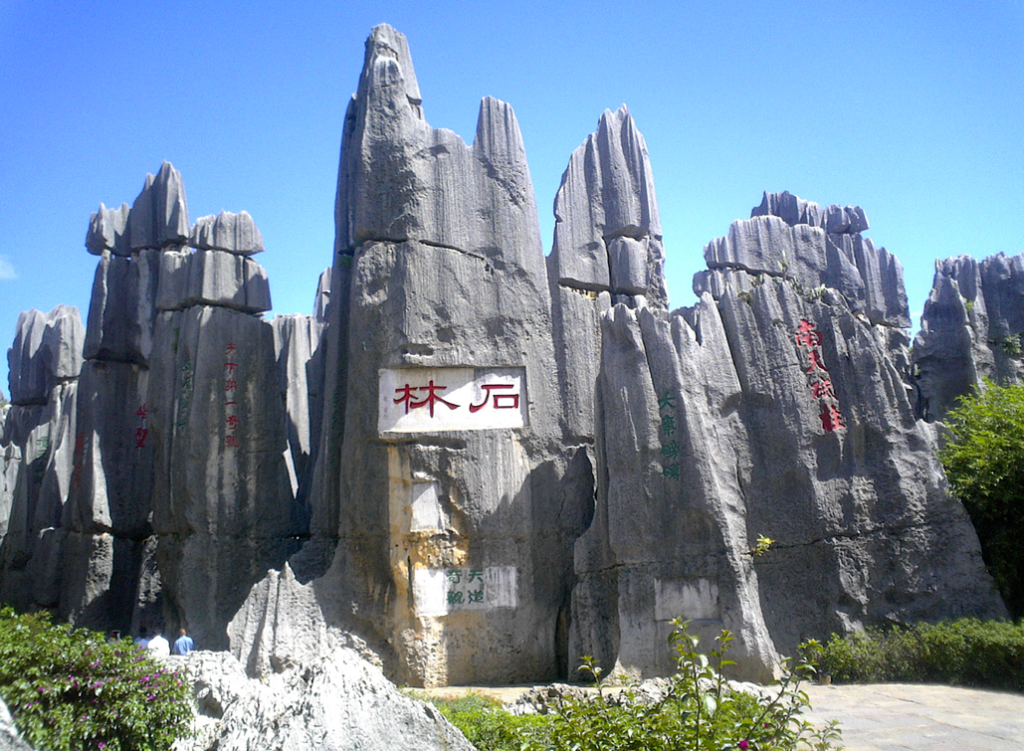 A large rock formation with red writingDescription automatically generated