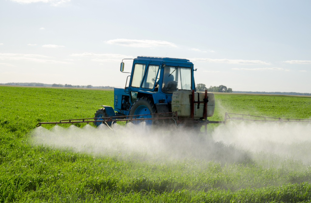 A tractor spraying a fieldDescription automatically generated