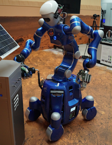 A blue robot with arms and legsDescription automatically generated