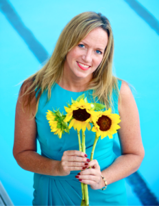 A person holding sunflowers in her handDescription automatically generated