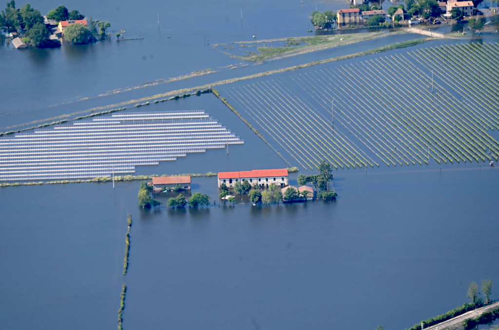 A flooded area with houses and fieldsDescription automatically generated