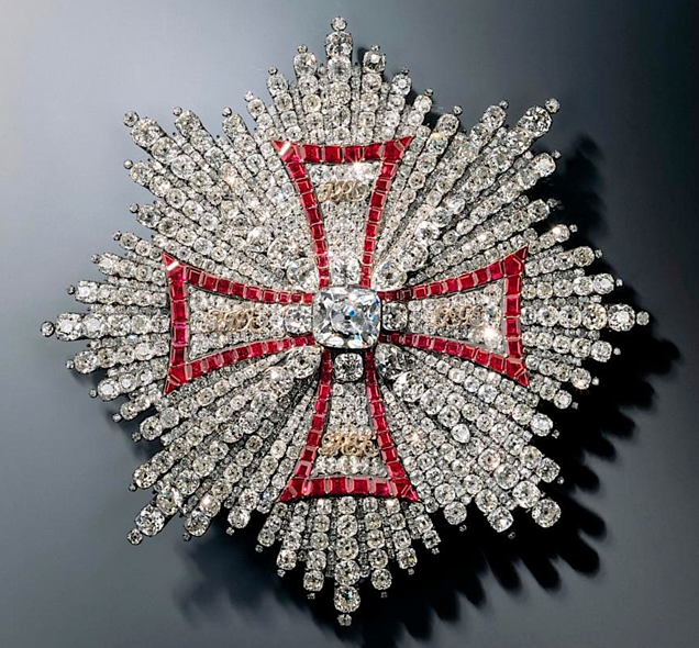 A close-up of a diamond and red crossDescription automatically generated