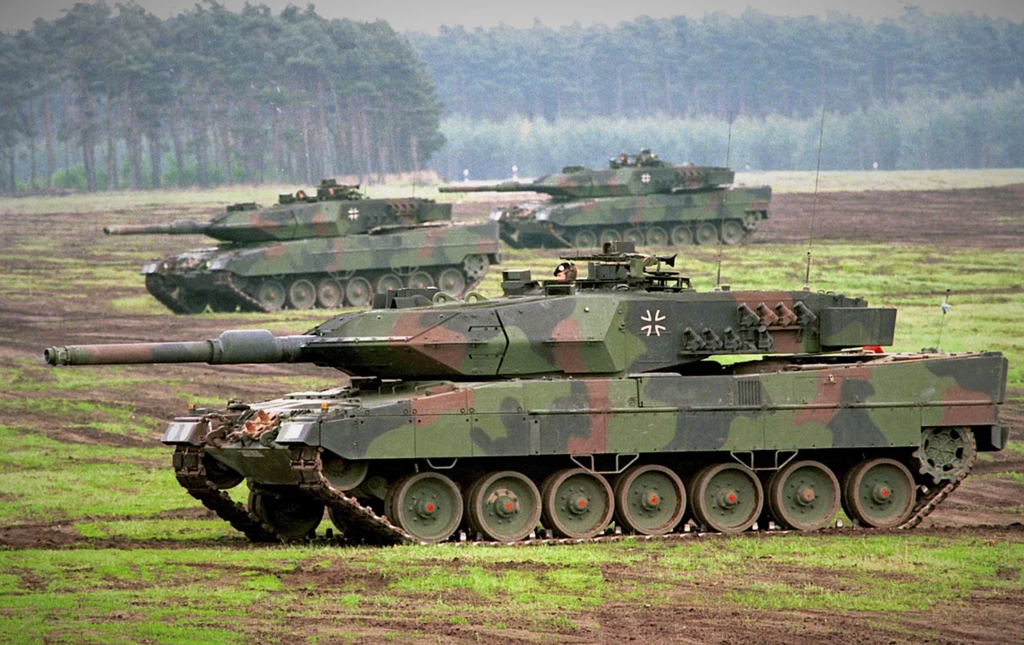 A group of military tanks in a fieldDescription automatically generated