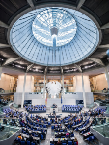 A group of people in a round room with Ronald Reagan Building and International Trade Center in the backgroundDescription automatically generated