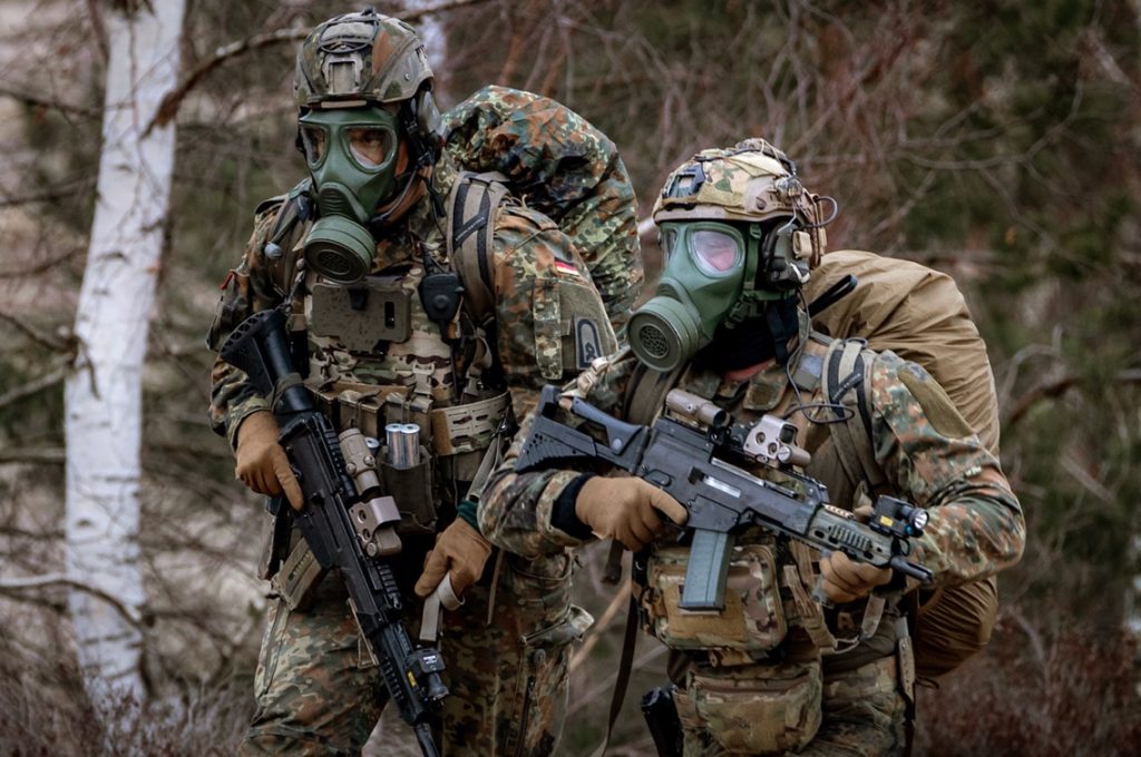 A group of people in military uniforms holding gunsDescription automatically generated
