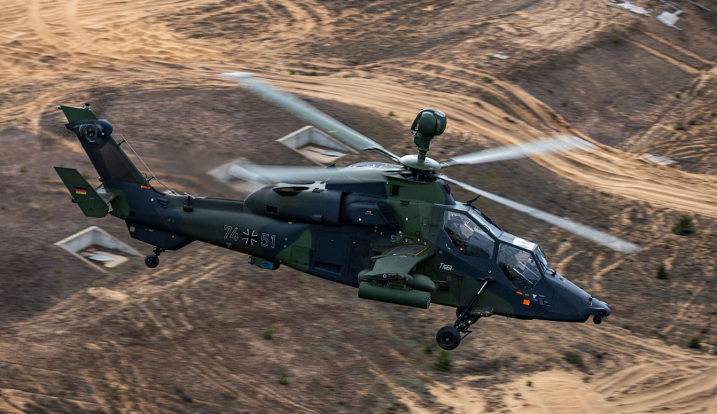 A helicopter flying over a desertDescription automatically generated