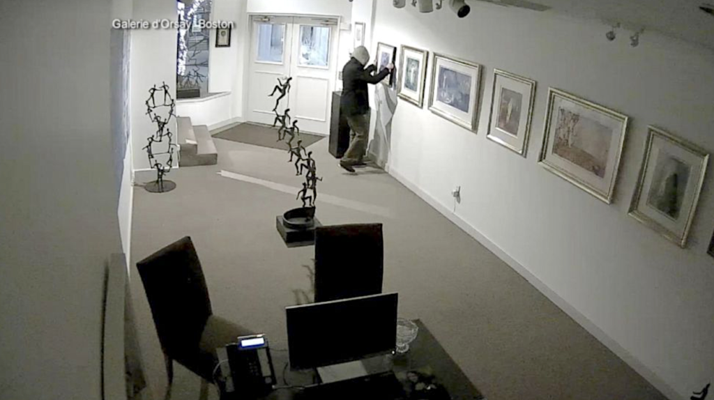 A person standing in a room with a few pictures on the wallDescription automatically generated