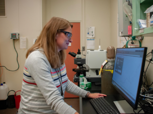 A person wearing goggles and using a computerDescription automatically generated