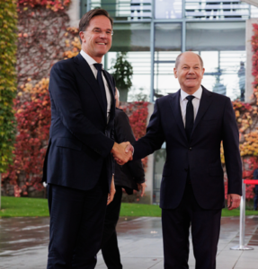 Two men in suits shaking handsDescription automatically generated