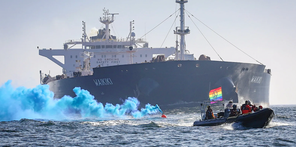 A boat with a rainbow flag in the waterDescription automatically generated