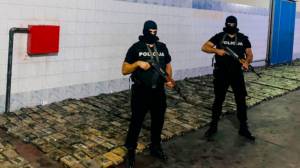 A group of men wearing black uniforms and holding guns

Description automatically generated
