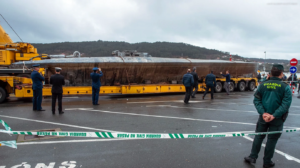 A group of people standing next to a large yellow truckDescription automatically generated