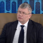 A person in a suit and tieDescription automatically generated