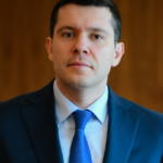 A person in a suit and tieDescription automatically generated