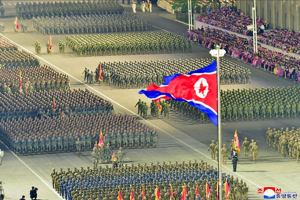 A group of people marching in military uniformsDescription automatically generated