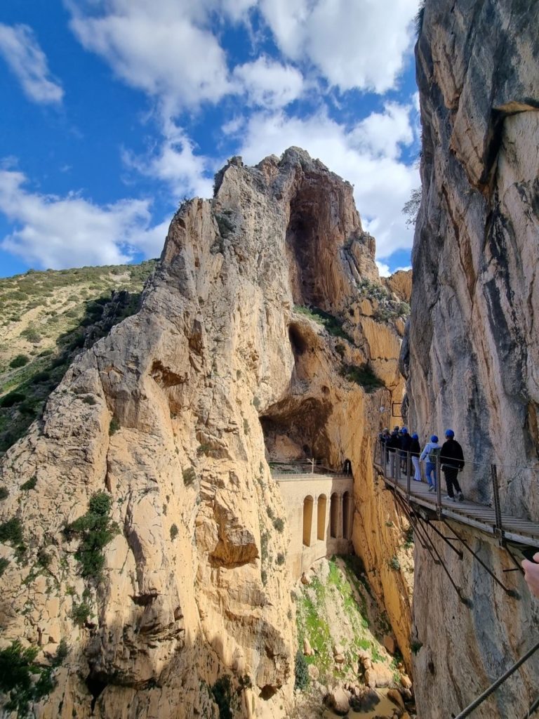 A group of people walking on a bridge Description automatically generated