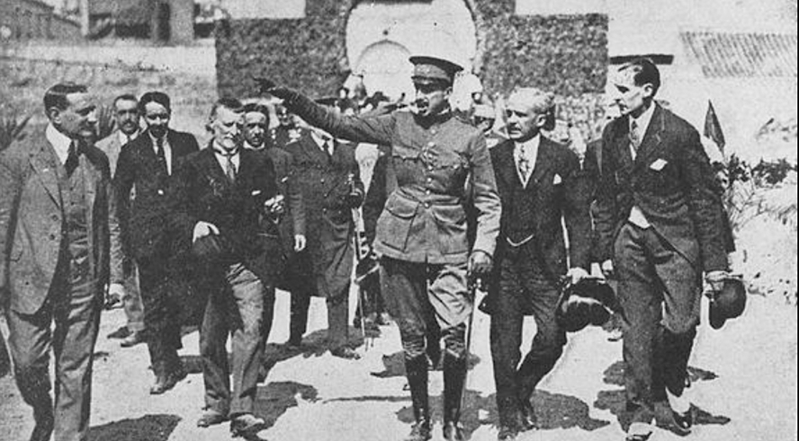 A person in a military uniform saluting with a group of men Description automatically generated