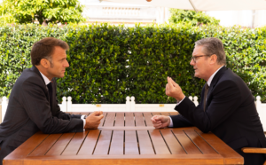 Two men sitting at a tableDescription automatically generated