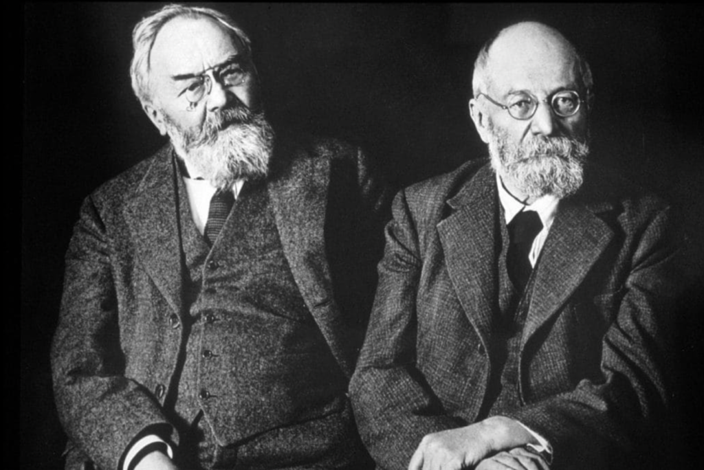 A couple of men in suits Description automatically generated