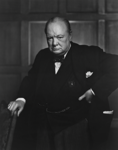 A person in a suit with his hand on his hipDescription automatically generated