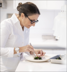 A person in a white coat Description automatically generated
